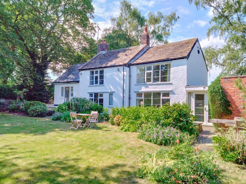 a white house with a garden in front of it at The Mill Cottage in Ault Hucknall