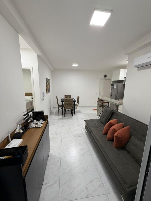 a large living room with a couch and a kitchen at Apartamento Loretto in Espirito Santo Do Pinhal