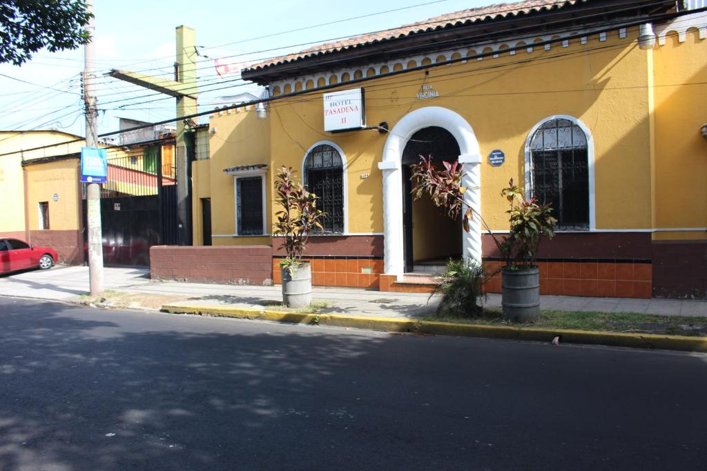 un edificio amarillo al lado de una calle en Hotel Pasadena II en San Salvador