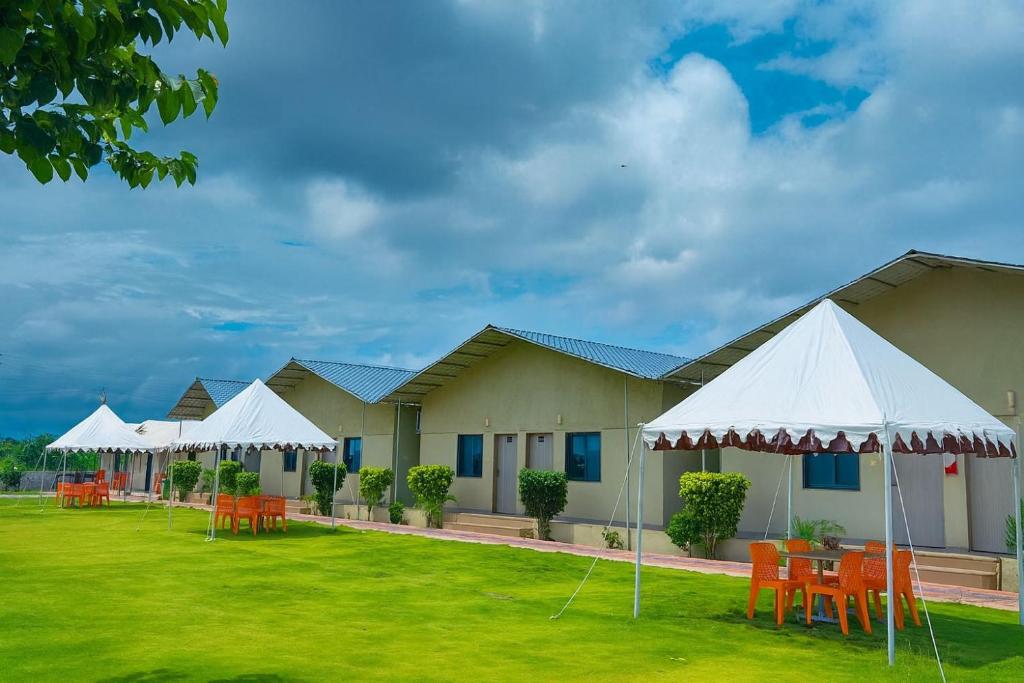 a row of buildings with tables and white tents at Unity Sunrise Resort Statue of Unity Ekta Nagar in Kevadia