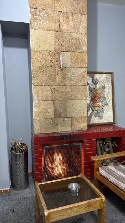 a brick fireplace with a fire in a room at Faraya chalet in Fārayyā