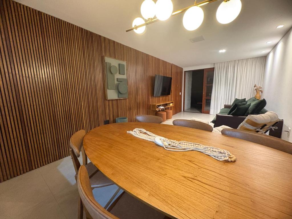a room with a wooden table with chairs and a living room at Diamantino Residence - apt 07 CalmariaMucuge in Mucugê