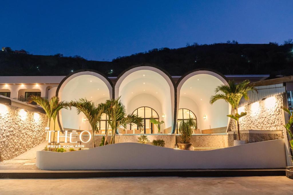 a building with palm trees in front of it at Théo Privé Kohlarn in Ko Lan