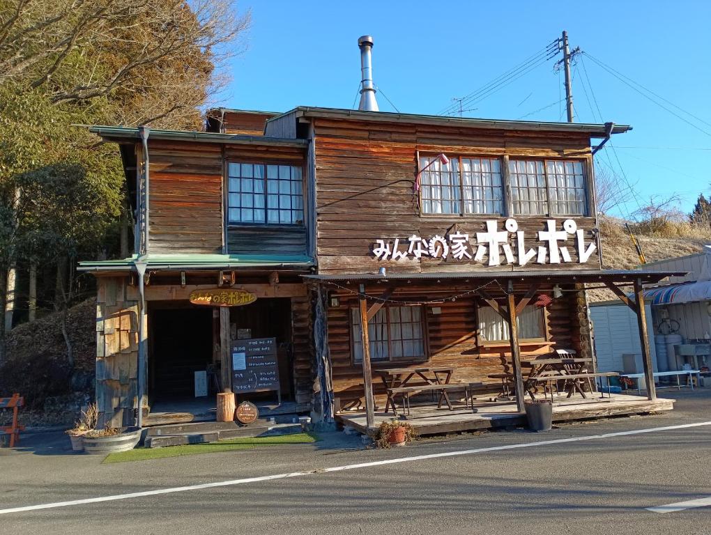 a wooden building with chinese writing on it at みんなの家ポレポレ in Urugi
