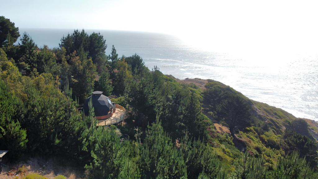 a train on a hill next to the ocean at Villa Santa Rita in Cobquecura