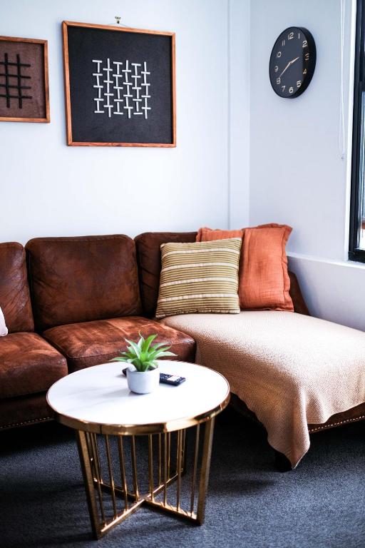 a living room with a couch and a table at Top Floor - Secure Parking - Great Location - Quiet - City Ciew in Wellington