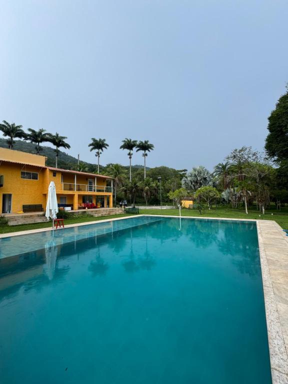 a large swimming pool in front of a building at Sítio Mais Lindo do Mundo in Ilha de Guaratiba