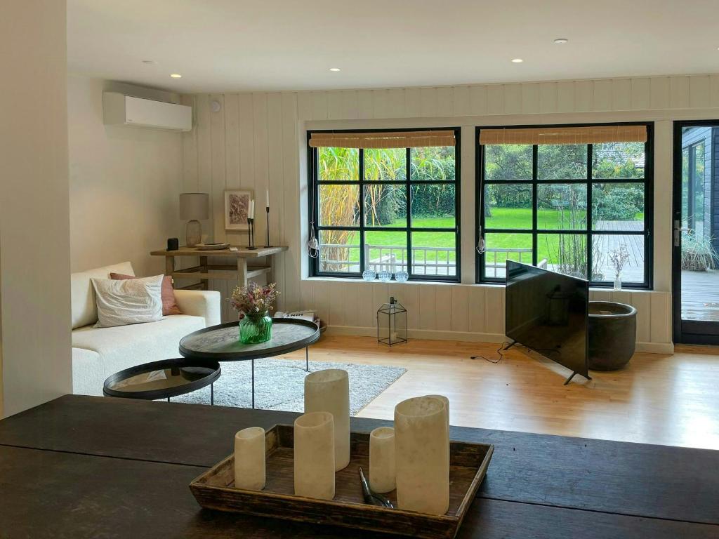 a living room with a couch and a tv at Stylish House Between Beach And Forest In Tisvilde in Tisvilde