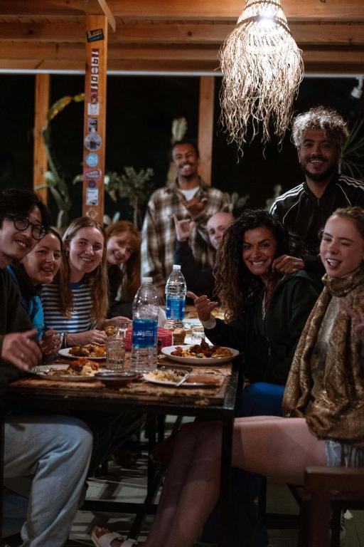 a group of people sitting around a table eating at We surf Morocco BOUTIQUE HOUSE in Taghazout