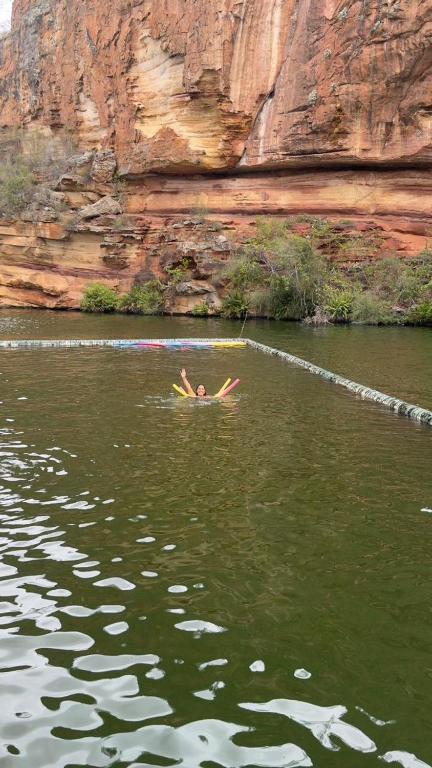 a person swimming in a body of water at Aconchego em Piranhas in Piranhas