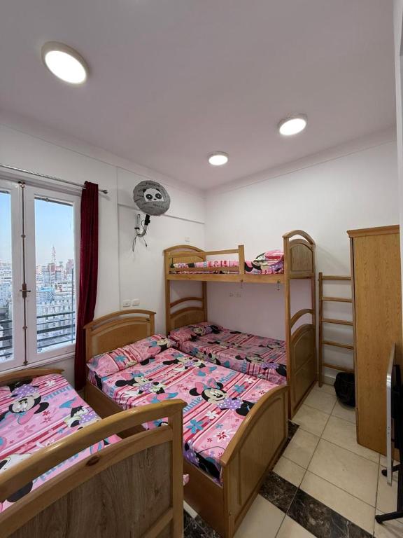 a room with three beds and a window at Nabi Daniel Residence بيت البنات in Alexandria