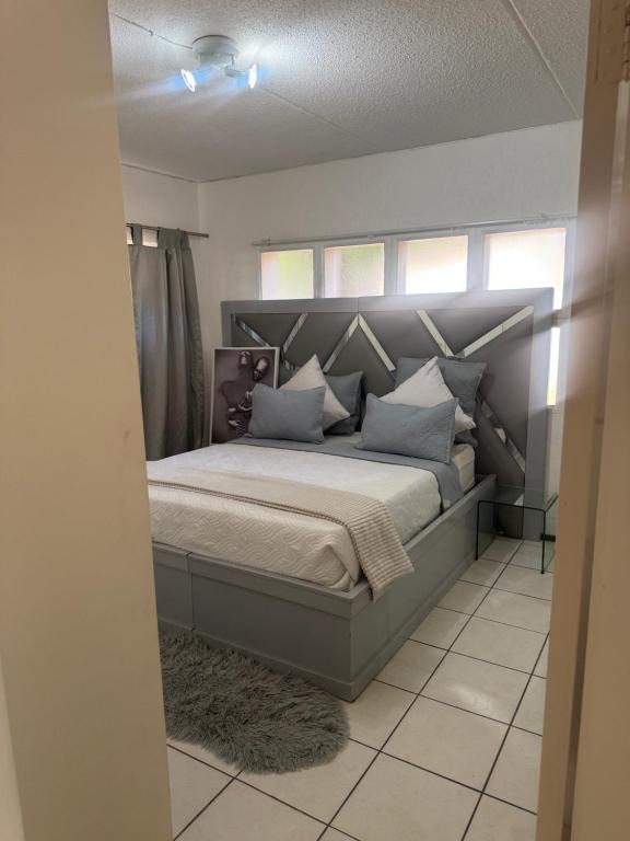 a bedroom with a large bed with blue pillows at House by balinty in Johannesburg