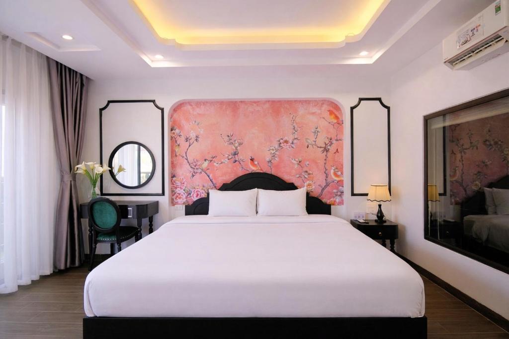 a bedroom with a white bed and a pink wall at Stella De Boutique Hotel in Sapa