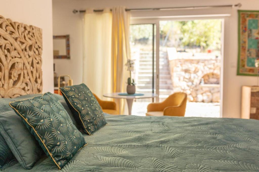 a bedroom with a green bed with a view of a patio at Studio le nid avec piscine partagée in Flayosc
