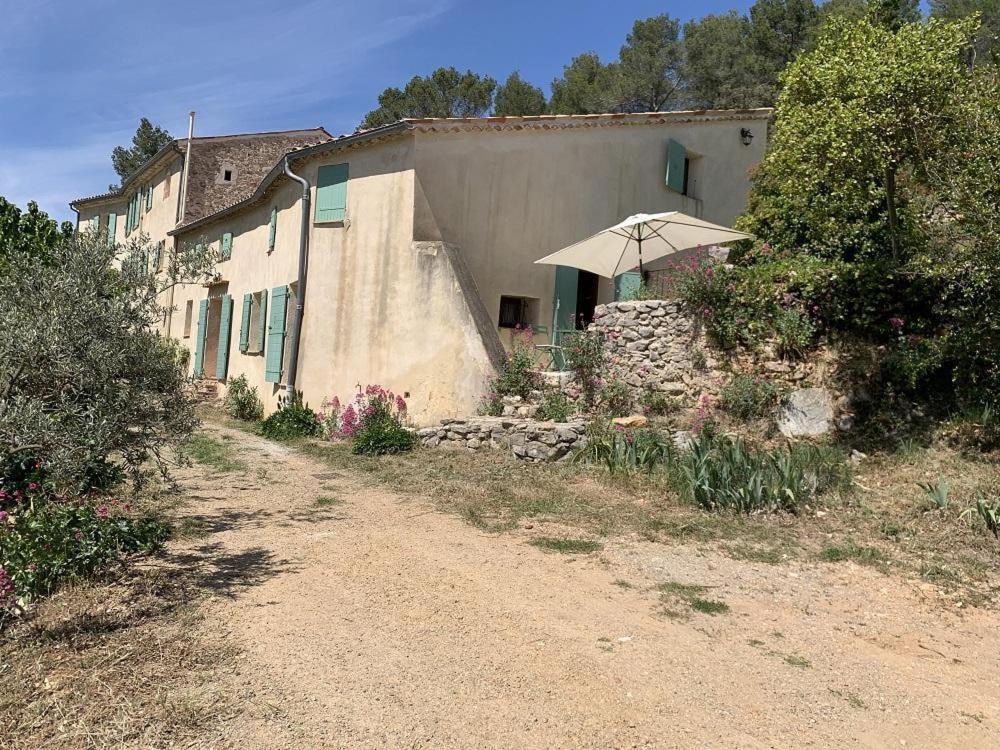 a house with an umbrella next to a dirt road at Mas de la clue - 2 personnes in Figanières