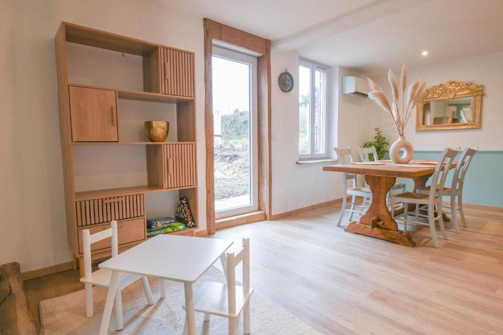 a dining room with a table and a table and chairs at Chez nenette in Prugny