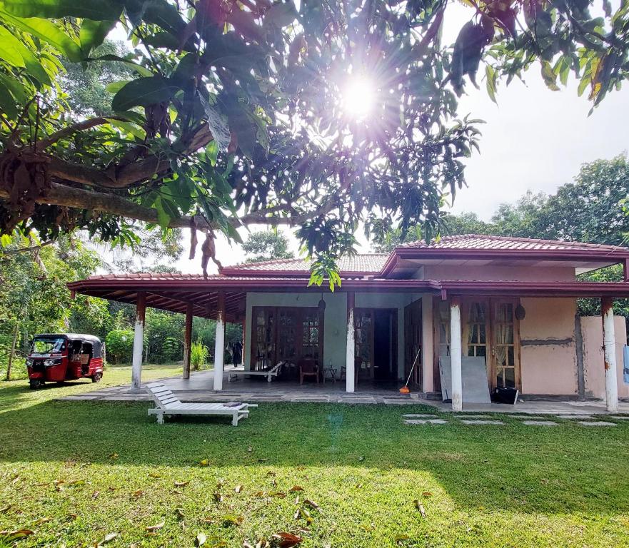 a house with a porch and a person on the roof at Sansayin Homestay in Hambantota