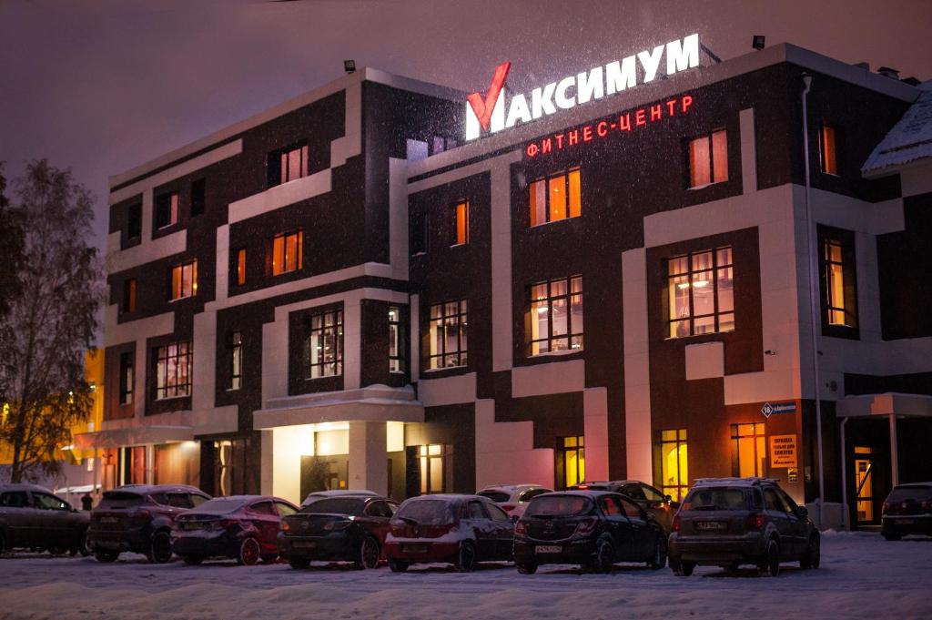 ケメロヴォにあるSport Hotel Maximumの車が停まった建物