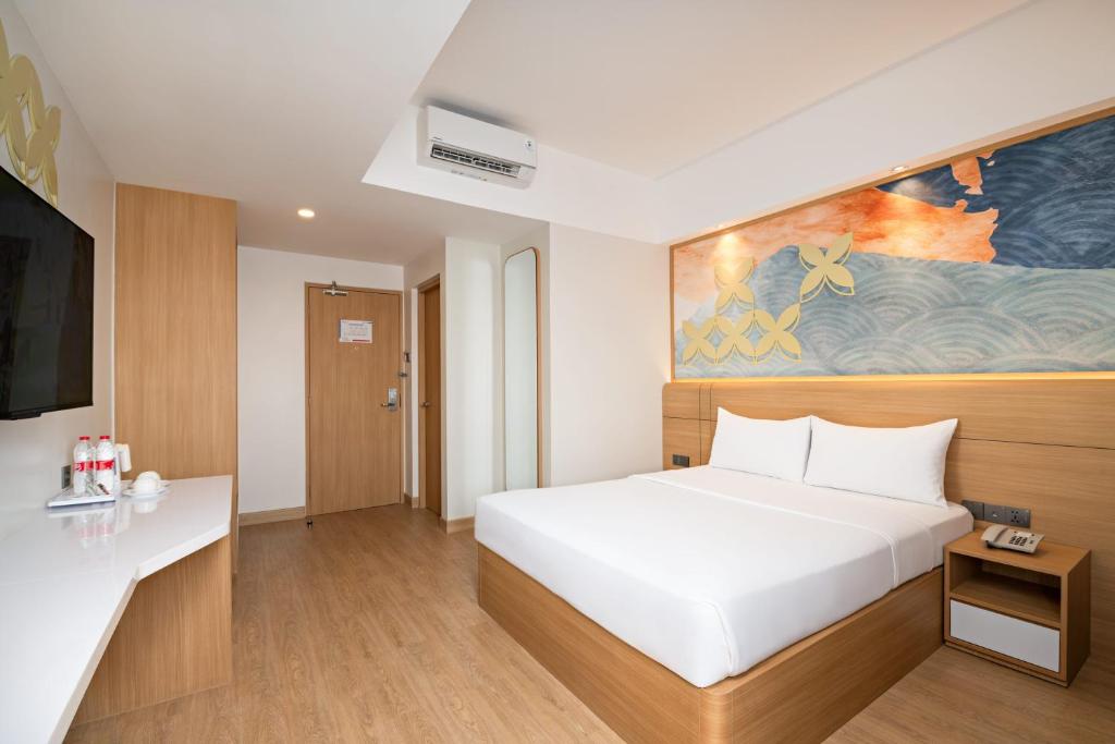a bedroom with a white bed and a painting on the wall at Metland Hotel Bekasi in Bekasi