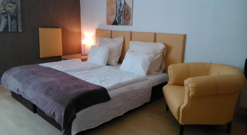 a bedroom with a bed and a chair in it at Apartment Sova in Ostrava