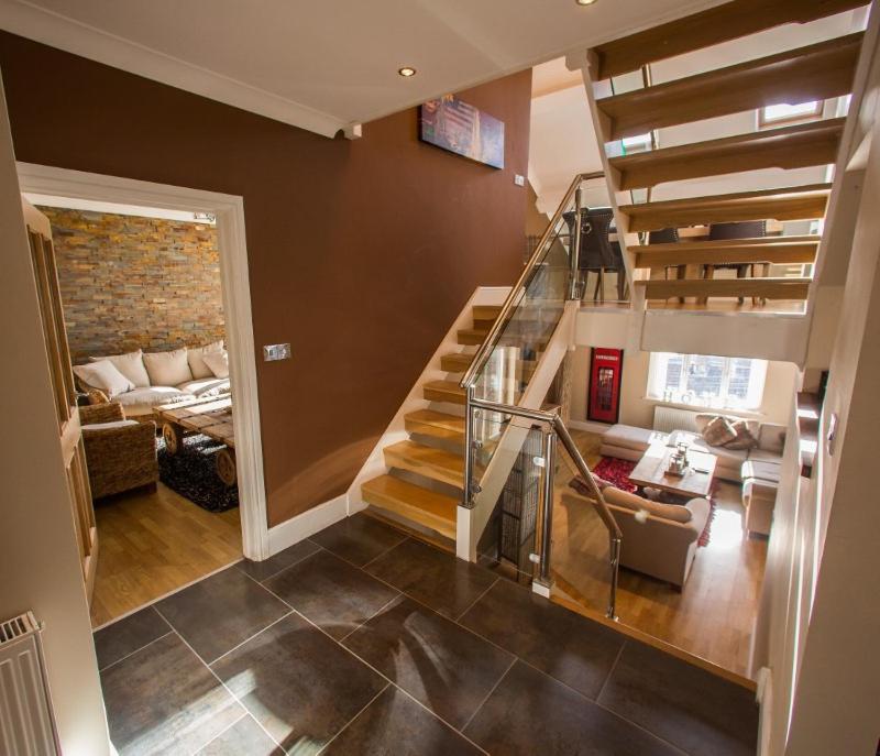 a room with a staircase and a living room at Brecon Beacons Welsh Countryside Retreat in Merthyr Tydfil
