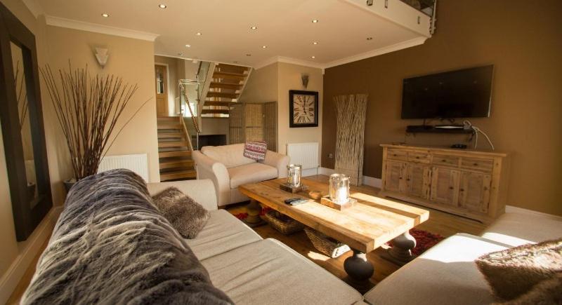 a living room with a couch and a coffee table at Luxury Model Home, Sandbrook Villas in Merthyr Tydfil