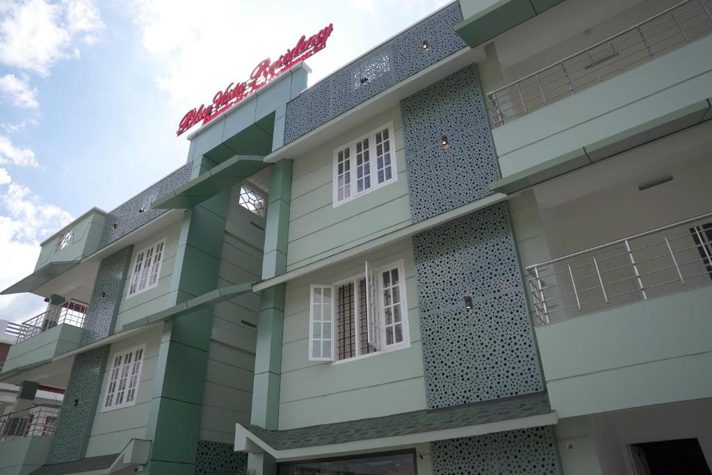 a facade of a building with white and green at Blue Vista Residency in Kalpetta