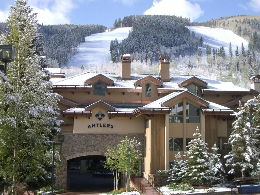 a ski lodge with a snow covered mountain in the background at Antlers at Vail Resort in Vail