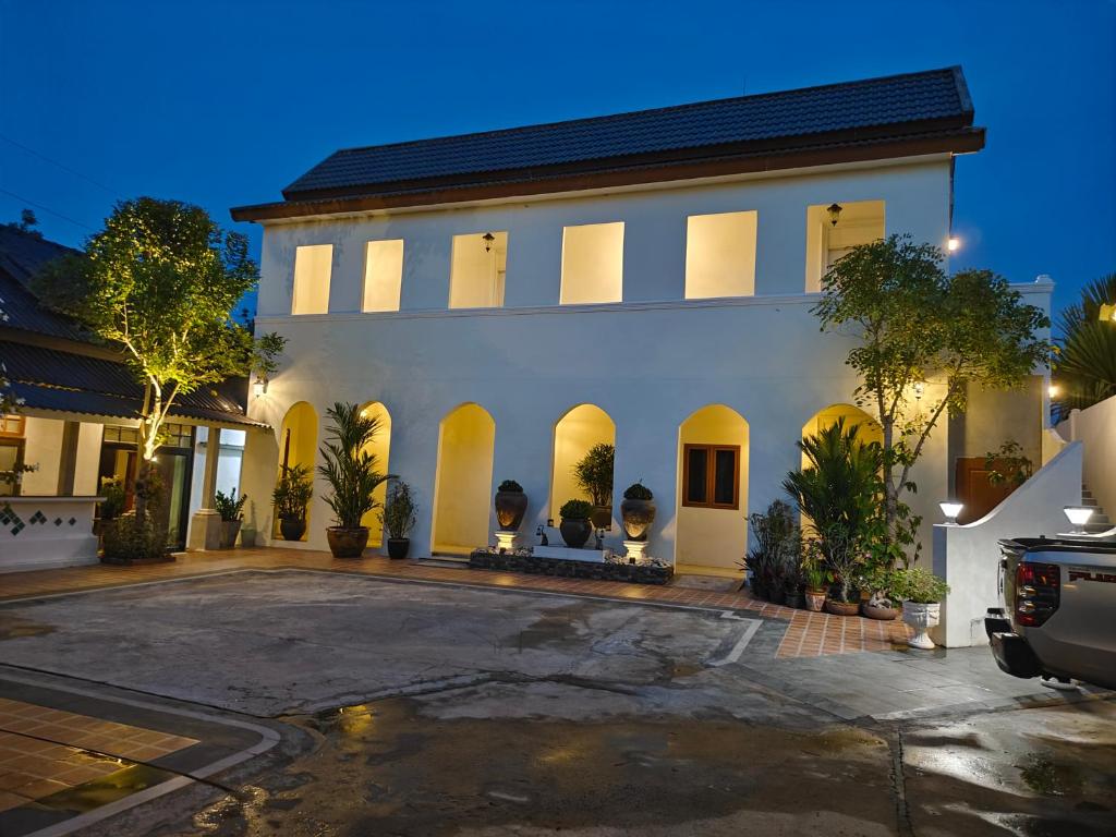 a large white building with a parking lot at Phu View Hideaway in Ban Kham Proi