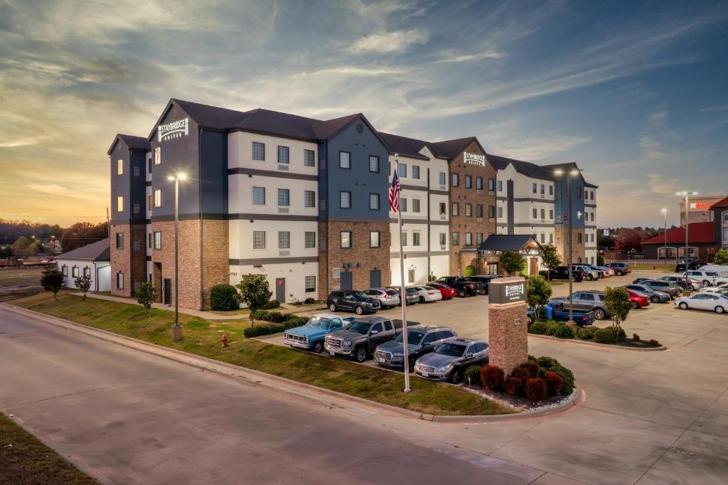 ein Wohnhaus mit auf einem Parkplatz abgestellten Autos in der Unterkunft Staybridge Suites Longview by IHG in Longview