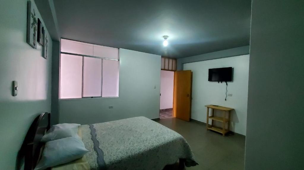 a bedroom with a bed and a window and a television at Hab simplex in Cajamarca