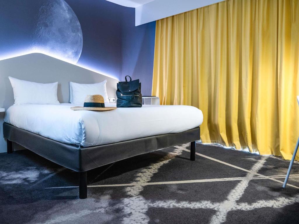 a bedroom with a bed with a moon on it at ibis Styles Paris Charles de Gaulle Airport in Roissy-en-France