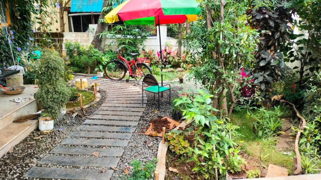 a garden with a table and a colorful umbrella at Swanky Homestay GHAR wali feeling in Kolhapur