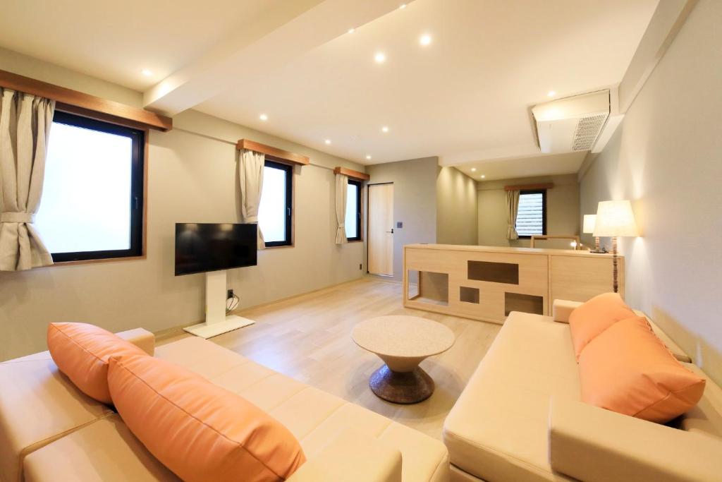 a living room with a couch and a tv at ゆるり箱根withDOGS in Hakone