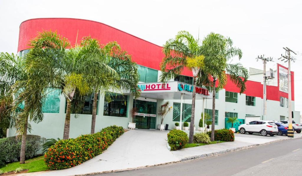 um hotel com palmeiras em frente a um edifício em Hotel Alji em Indaiatuba