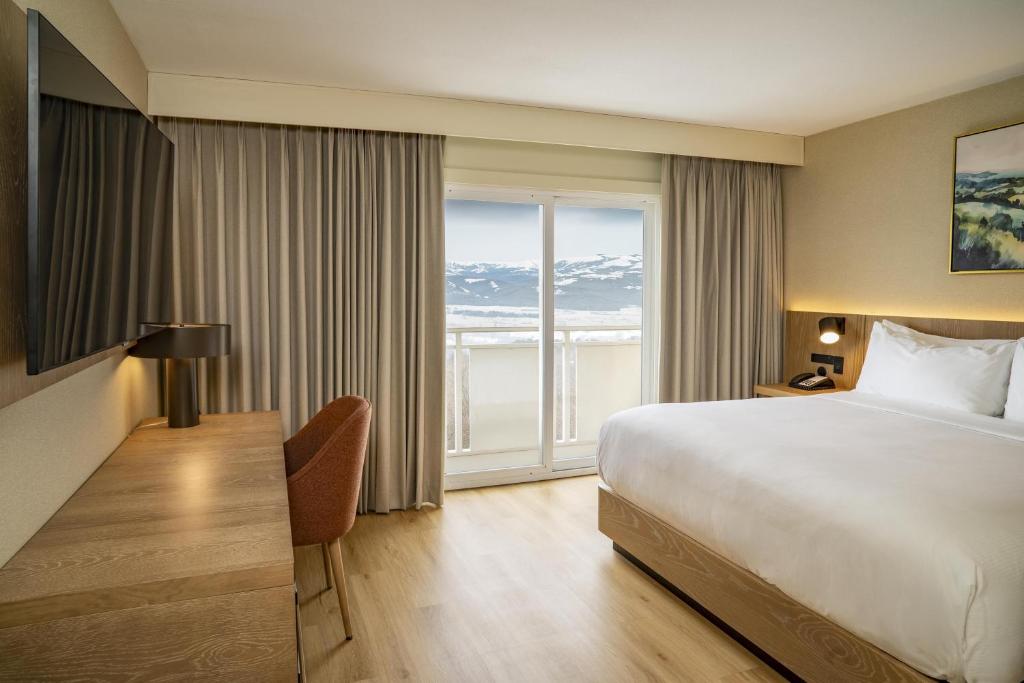 a hotel room with a bed and a large window at DoubleTree by Hilton Wilkes-Barre in Wilkes-Barre