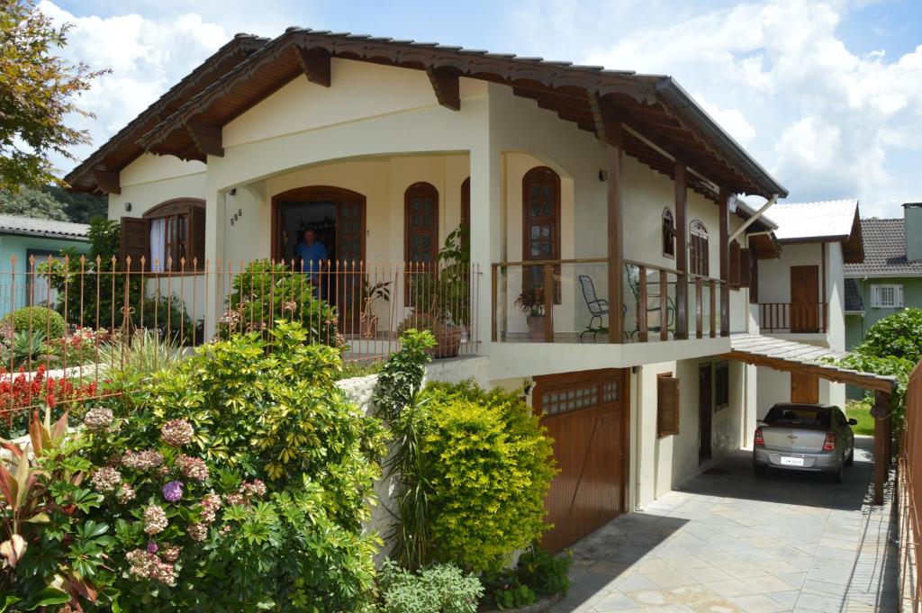 a house with a car parked in front of it at Pousada Theisen in Gramado