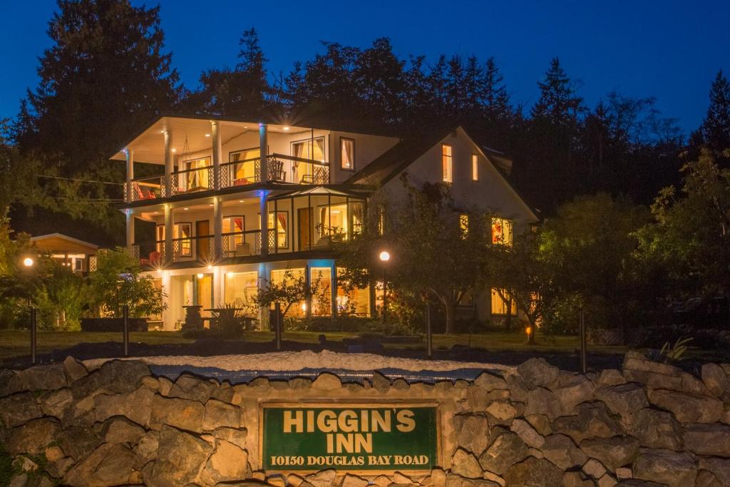une maison la nuit avec un panneau devant elle dans l'établissement Higgin's Inn, à Powell River