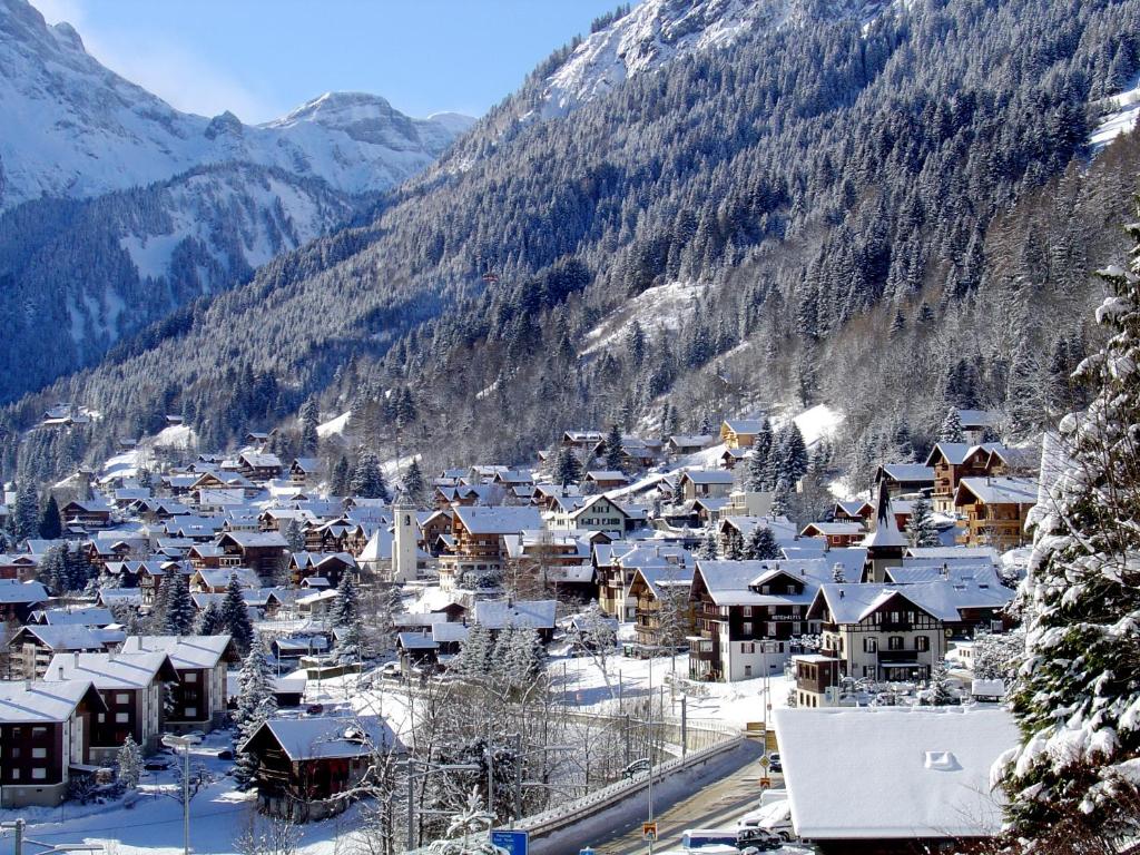 a village covered in snow with mountains in the background at Chalet Hestia in Champéry