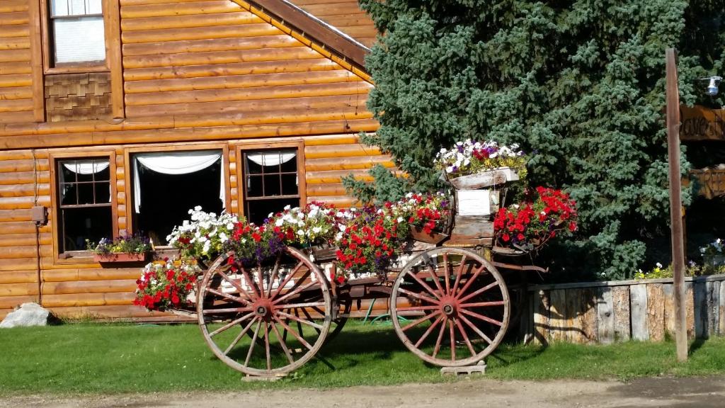 a wooden cabin with a carriage filled with flowers at Daven Haven Lodge & Cabins in Grand Lake