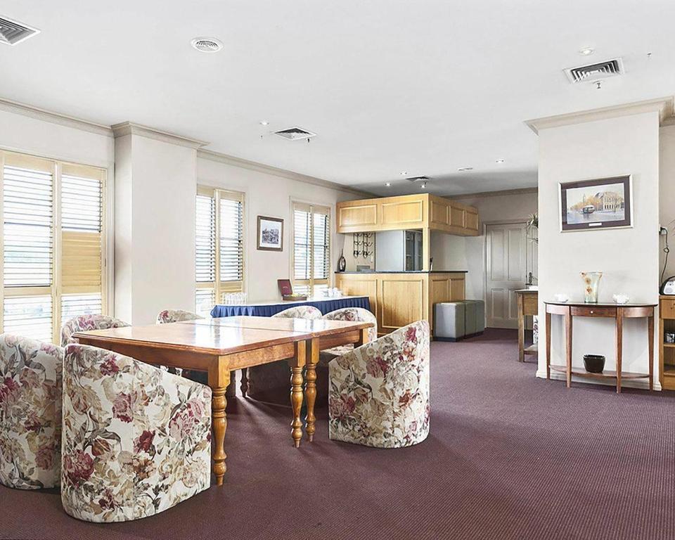 a living room with a wooden table and chairs at Quality Inn Colonial in Bendigo