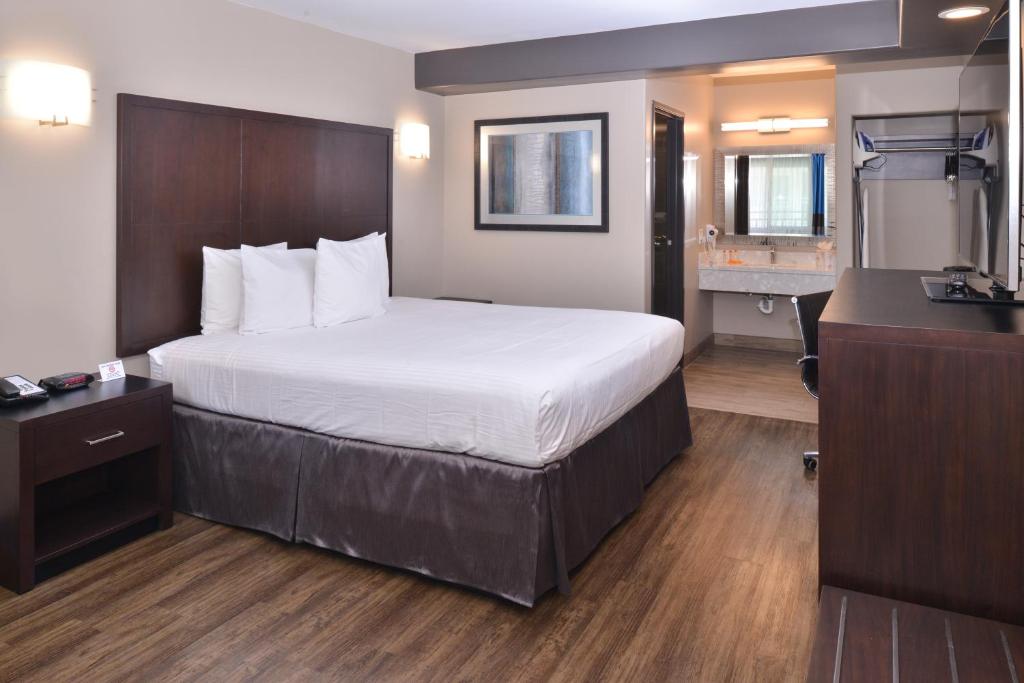 a hotel room with a bed and a bathroom at Tarzana Inn in Tarzana