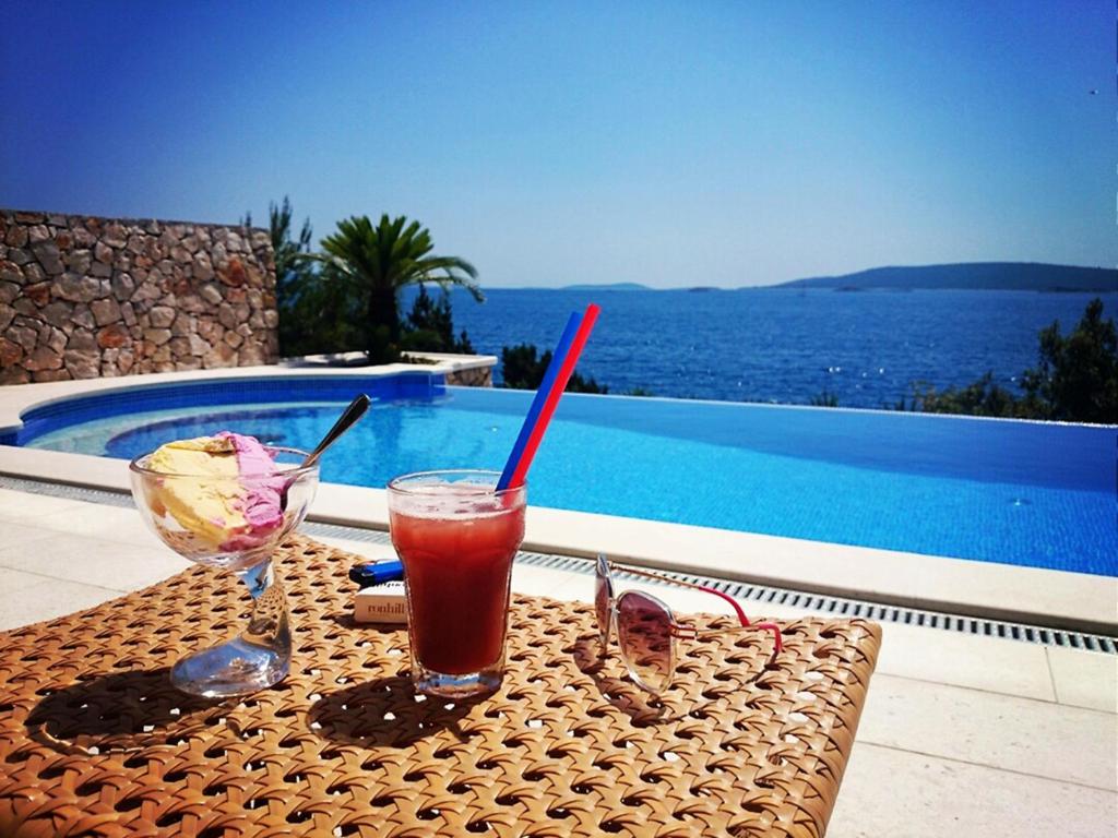 een tafel met een drankje en een schaal ijs bij Villa Vesna Private Beach in Okrug Donji