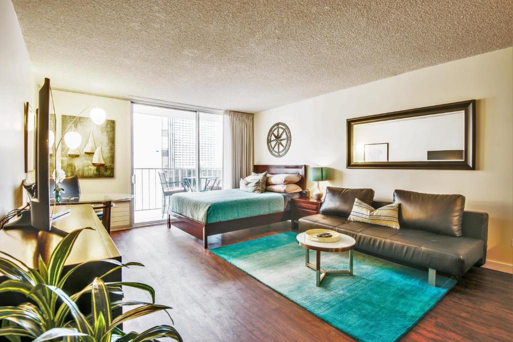 a living room with a couch and a table at Waikiki Place Studios at The Marine Surf Waikiki in Honolulu