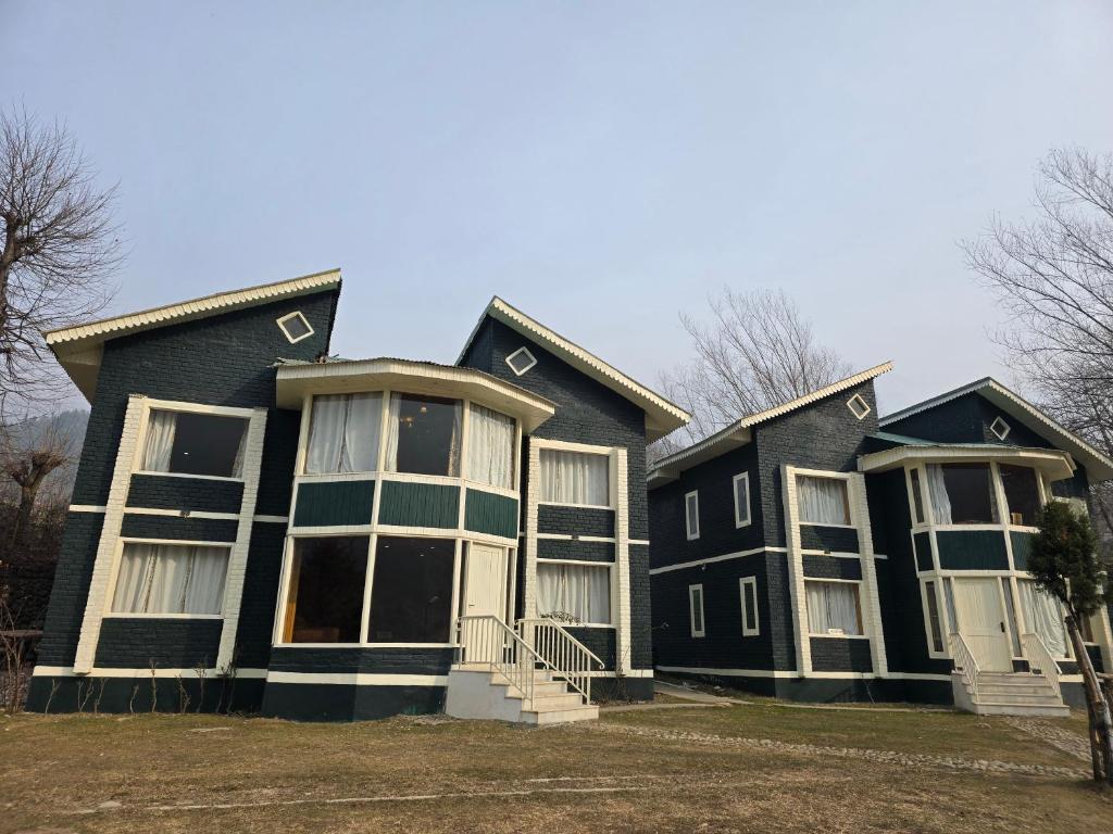 a large black house with white windows at The Pinus Resort in Pahalgām