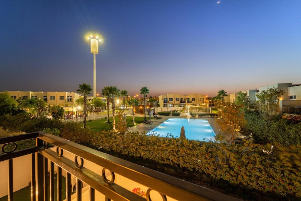 a view of a pool from a balcony at night at FIRST CLASS Villa Peaceful Pool View Retreat in Dubai