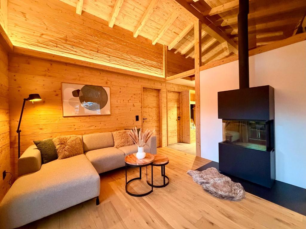 a living room with a couch and a tv at Chalet Spatz Loft with Sauna Kandersteg Oeschinen Lake in Kandersteg