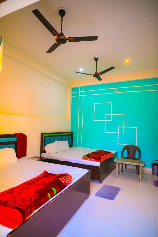 a bedroom with two beds and a ceiling fan at Shri ram doot niwas in Ayodhya