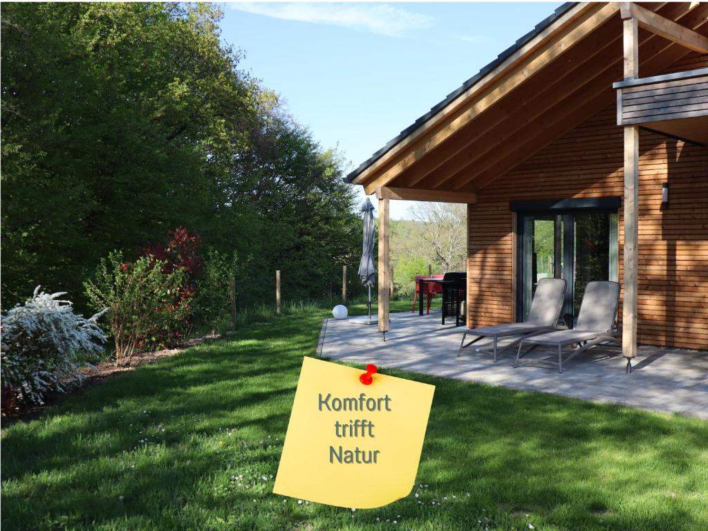 ein Schild im Gras vor einem Haus in der Unterkunft Traumweiler Ferienhäuser am Nationalpark Hunsrück Hochwald - barriearm - mit effektiver Kühlung in Kirschweiler
