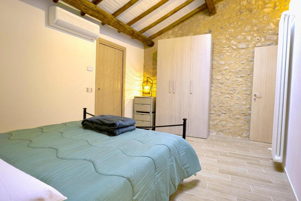 a bedroom with a bed and a stone wall at Alloggio turistico Alla Vasca in Tregnago
